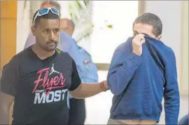  ?? Jack Guez AFP/Getty Images ?? AN ISRAELI AMERICAN teenager is led away from a court in Rishon LeZion, Israel, after being charged with making bomb threats against U.S. Jewish centers.