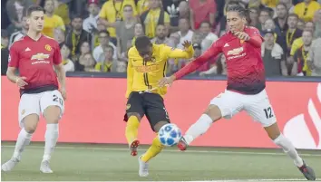  ?? — AFP ?? Young Boys Ivorian Roger Assalé (centre) shoots past Manchester United’s Chris Smalling (right) and Diogo Dalot (left) during the UEFA Champions League group H match at The Stade de Suisse in Bern on Wednesday.