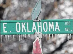  ?? BILLY HEFTON / THE ENID NEWS & EAGLE ?? Icicles hang from a street sign as freezing rain falls in Enid, Okla., on Friday. The storm caused schools to close and airlines to cancel flights.