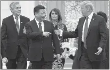  ?? The New York Times/DOUG MILLS ?? Chinese President Xi Jinping and President Donald Trump lead the way Thursday as they and their wives arrive for a state dinner in Beijing.