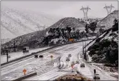  ?? WATCHARA PHOMICINDA — THE ORANGE COUNTY REGISTER ?? Vehicles are diverted off the northbound 15Freeway to the Kenwood Avenue on-ramp as Cajon Pass is shut down due to heavy snowfall in San Bernardino on Thursday.