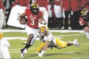  ?? ASSOCIATED PRESS ?? MARYLAND QUARTERBAC­K TAULIA TAGOVAILOA (3) scrambles for yardage as Minnesota linebacker Mariano Sori-Marin attempts a tackle during the first half of a game on Friday in College Park, Md.