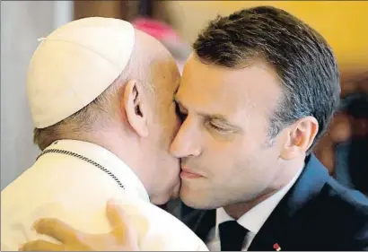  ?? ALESSANDRA TARANTINO / AFP ?? Emmanuel Macron abraza al papa Francisco al final de su audiencia en el Vaticano