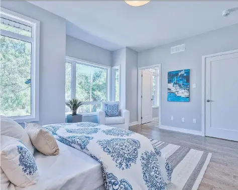  ?? HAMEL ?? An ocean-inspired master bedroom uses bold prints balanced with sky-blue walls, driftwood-like flooring and hints of the sea and sand.