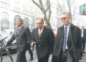  ?? — Bernama photo ?? Anwar (centre) is seen walking to the Round Table Meeting with Captains of Industry. Accompanyi­ng him is Zafrul.