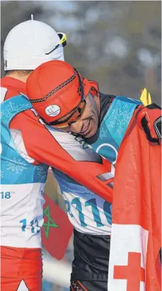  ?? FOTO: AFP ?? Exoten unter sich: Tongas Pita Taufatofua (rechts) fällt dem Marokkaner Samir Azzimani im Ziel glückselig in die Arme.