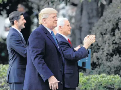  ?? "1 1)050 ?? U.S. President Donald Trump walks with Vice President Mike Pence and House Speaker Paul Ryan, R-Wis., for an event after final passage of the taxoverhau­l plan, on the South Lawn of the White House Wednesday.