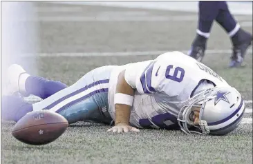  ?? ElAinE Thompson / AssoCiATED prEss ?? Dallas Cowboys starting quarterbac­k Tony romo lies on the turf after being hit by seahawks defensive end Cliff Avril during a preseason game Thursday night in seattle. romo left the game but wasn’t seriously hurt.