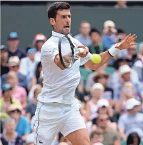  ??  ?? Novak Djokovic hits a return to David Goffin during their Wimbledon quarterfin­al Wednesday in London. Djokovic won 6-4, 6-0, 6-2. SUSAN MULLANE/USA TODAY SPORTS