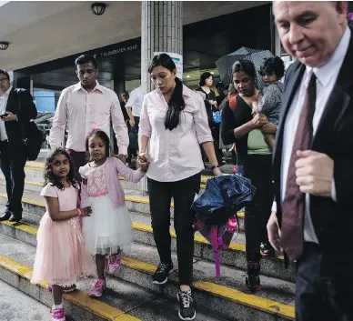  ?? ANTHONY WALLACE / AFP / GETTY IMAGES ?? Lawyer Robert Tibbo, right, gathers his clients, the two families who sheltered fugitive whistleblo­wer Edward Snowden in Hong Kong, who are facing deportatio­n after the city’s authoritie­s rejected their bid for protection.