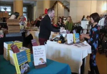  ??  ?? An event-goer purchases author Will Schwalbe’s books The End of Your Life Book Club and Books for Living at the 14th annual Fall Lecture Luncheon, presented by Saratoga Performing Arts Center’s Action Council.