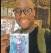  ??  ?? Barry Jenkins enseña una copia pirata de su película “Luz de Luna (Moonlight)”, que encontró en una parada que hizo en Muna