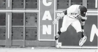  ?? Karen Warren / Staff photograph­er ?? Josh Reddick of the Astros tries to field a single by Robinson Cano of the Mariners during the first inning of Wednesday’s series finale at Minute Maid Park.