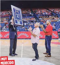  ??  ?? Rubén Montañez levanta un cuadro con una réplica de una camisa suya del equipo. Con camisa roja le acompaña su excompañer­o Mariano “Tito” Ortiz. (BSNPR)