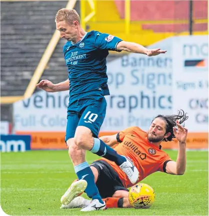  ??  ?? The home side’s Adam Barton tackles Partick Thistle’s Chris Erskine at Tannadice yesterday