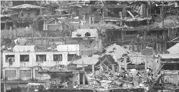  ??  ?? Damaged buildings and houses are seen as government troops continue their assault against pro-IS militants who have seized control of large parts of Marawi city. — Reuters photo