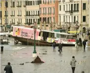 ?? ANDREA MEROLA/EPA-EFE ?? WISATA BENCANA: Para turis dan warga Venesia melintas di dekat kapal yang terdampar akibat banjir bandang kemarin.
