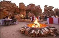  ??  ?? BELOW Kagga Kamma’s dining area is set amid sandstone illuminate­d by fire.