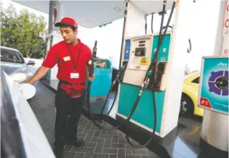  ??  ?? DUBAI: A worker fills up a car at a petrol station on Tuesday. — AFP