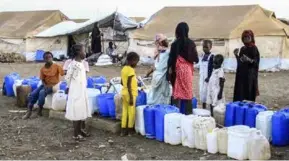  ?? AFP/VNA Photo ?? Women and children queue for water at Huri camp for the displaced south of Gedaref in east Sudan, on March 29.