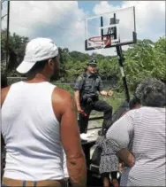  ?? GINGER RAE DUNBAR – DIGITAL FIRST MEDIA ?? Coatesvill­e police Sgt. Rodger Ollis speaks to the crowd about the new basketball net which police placed on Monday on Elm Street.