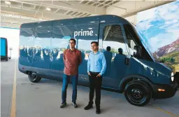  ?? MUSTAFA HUSSAIN/GETTY ?? Rivian CEO R.J. Scaringe and Amazon Vice President of Transporta­tion Udit Madan stand by an electric vehicle on July 21 at an Amazon facility in Chicago.