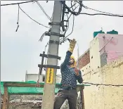  ?? SNIGDHA POONAM/HT ?? (From left) A line man from the Noida Power Corporatio­n Limited removes unauthoris­ed cables in Greater Noida’s Surajpur village, a task that officials say puts them on the receiving end of people’s anger