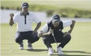  ??  ?? 2 Dustin Johnson, right, and Brooks Koepka line up a putt during the foursomes at Le Golf National.