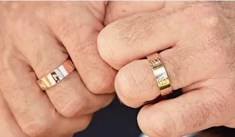  ??  ?? Los anillos, de oro rosado, inspirados en el modelo de Cartier, pero en vez de los “tornillos” del tradiciona­l diseño, los recién casados pusieron sus iniciales.