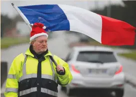  ?? (Pascal Rossignol/Reuters) ?? A PROTESTER wearing a yellow vest and holding a French flag protests in Somain in northern France yesterday.