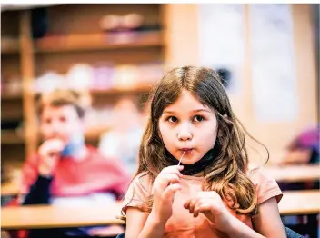  ??  ?? Die sieben Jahre alte Helena von der Paulusschu­le macht am Montagmorg­en ihren ersten Lolli-Test. Das Fazit der Zweitkläss­lerin: Er schmeckt nach Haaren.