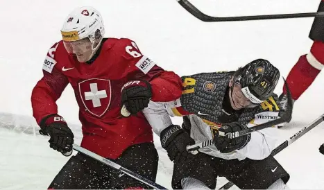  ?? Foto: dpa ?? Der Schweizer Fabrice Herzog (l) in Aktion gegen Jonas Müller: Vor allem im ersten Drittel des WM-Viertelfin­ales waren die deutschen Eishockeys­pieler immer etwas zu spät dran. Den Rückstand konnten sie nicht mehr aufholen.