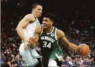  ?? Stacy Revere / Getty Images ?? The Bucks’ Giannis Antetokoun­mpo drives around the Celtics’ Grant Williams during the second half of Game 6 of the Eastern Conference Semifinals on Friday.