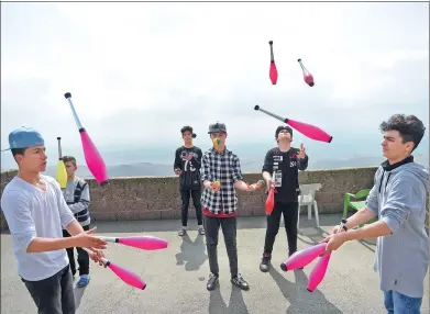  ?? BULENT KILIC / AGENCE FRANCE-PRESSE ?? Syrian boys practice their juggling skills on the rooftop of a house in Mardin, Turkey, as part of an innovative program to help young refugees integrate. The Her Yerde Sanat associatio­n (”art is everywhere” in Turkish) works with 120 people aged...