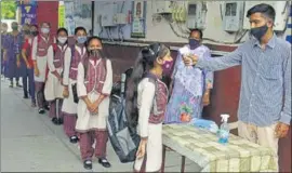  ?? SAMEER SEHGAL/HT ?? A teacher screening students for temperatur­e at a government senior secondary school in Amritsar on Monday.