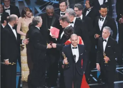  ??  ?? Fred Berger, foreground center, and the cast of “La La Land” mistakenly accept the award for best picture at the Oscars in Los Angeles on Sunday night. The actual winner of best picture was “Moonlight.” Chris Pizzello, Invision