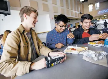  ??  ?? From left, Santa Fe High senior Willie Wiebe, 17, senior Isaac Hernandez, 17, and freshman Jorge Lozano, 15, eat lunch Tuesday in the school cafeteria. The school board on Tuesday voted to let high school seniors leave campus for lunch, effective in...