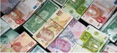  ?? —AP ?? ISTANBUL: Turkish liras, euros and US dollars are stacked at a currency exchange office in Istanbul, Turkey. Investors are now seeing the downside of one of 2015’s hottest investing trends: Exchange-traded funds that invest in foreign stocks while...