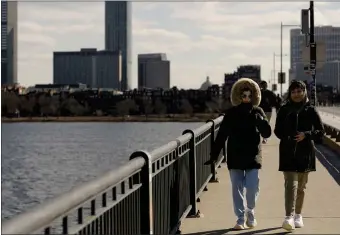  ?? LIBBY O’NEILL — BOSTON HERALD ?? Pedestrian­s are bundled up as they walk through the harsh winds blowing over Harvard Bridge Sunday.