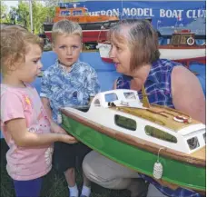  ??  ?? Helen Rivers shows off her 1/16th scale cabin cruiser to Erin, three, and Charlie Painter, five, on the Heron Model Boat Club’s stand