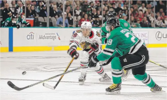  ??  ?? Blackhawks center Artem Anisimov takes a shot on goal as Stars defenseman Greg Pateryn ( right) and left winger Jamie Benn defend Saturday in Dallas. | MICHAEL AINSWORTH/ AP