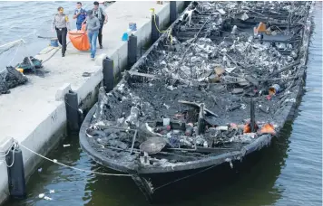  ?? — Reuters ?? The remains of a victim is carried away after a fire ripped through a boat carrying tourists to islands north of the capital, at Muara Angke port in Jakarta, Indonesia on Sunday.