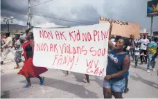  ?? JOSEPH ODELYN/AP ?? People demand the release of kidnapped missionari­es on Tuesday near Port-au-Prince, Haiti.