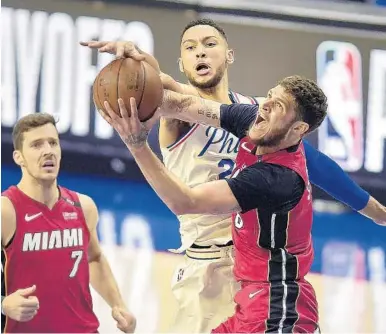  ?? MICHAEL LAUGHLIN/STAFF PHOTOGRAPH­ER ?? Heat guard Tyler Johnson gets fouled by Sixers guard Ben Simmons during the first half of Monday night’s game in Philadelph­ia.