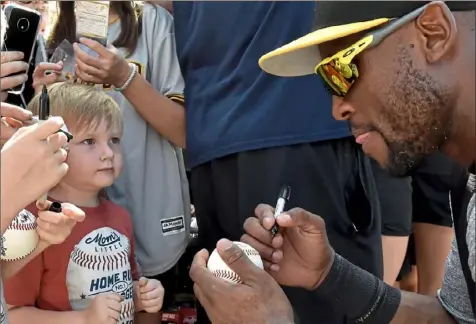  ??  ?? Easton McNeely, 3, of Brandon, Fla., keeps an eye on Starling Marte as he gets his ball signed after workouts Monday at Pirate City in Bradenton. Marte’s developmen­t into a leader in the Pirates organizati­on hasn’t been confined to the diamond.