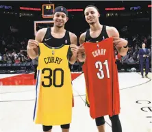  ?? Steve Dykes / Associated Press 2018 ?? Trail Blazers guard Seth Curry (left) and his brother, Warriors guard Stephen Curry, swap jerseys after a game in Portland.