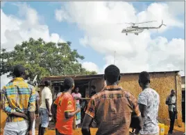  ??  ?? The Associated Press A Kenyan police helicopter flies Wednesday above the scene of an attack by gunmen who kidnapped an Italian volunteer in Chakama, Kenya.