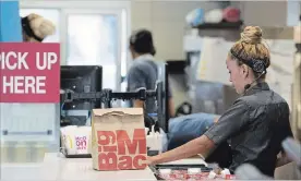  ?? BLOOMBERG FILE PHOTO ?? An employee packs an order for a customer at a McDonald's restaurant in Phoenix, Ariz.