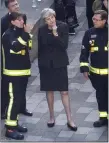 ??  ?? „ Theresa May speaks to London Fire Brigade officers at Grenfell.