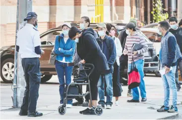  ?? Peter J. Thompson / national post ?? People wearing masks line up for access to new targeted measures at a Service Canada location on Toronto’s College Street on Thursday.